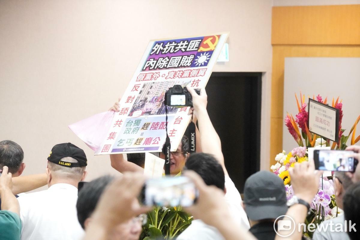 在黨外在野大聯盟今舉行成立大會，一位民眾在會場後方舉牌抗議，遭強行驅離。 圖：張良一/攝