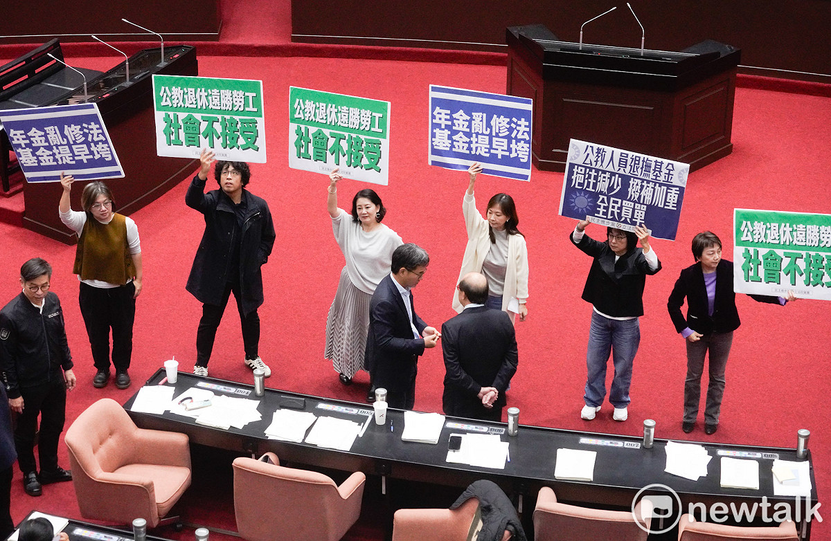 立法院院會今三讀通過年改法案：「公務人員退休撫卹法第37、38、67條條文修正草案。民進黨立委在表決前各自舉牌表訴立場。 圖：張良一/攝