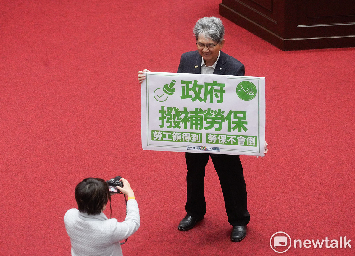 立法院院會今三讀通過勞保條例修正草案，將政府撥補法制化。圖為民進黨立委王旭正在三讀後拍照紀念。 圖：張良一/攝