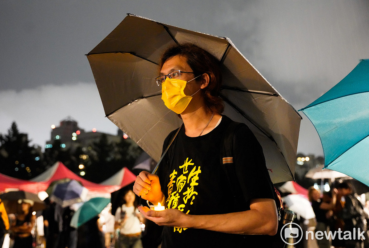 六四紀念晚會在滂沱大雨中舉行，民眾穿著雨衣、拿著雨傘與會。 圖：張良一/攝
