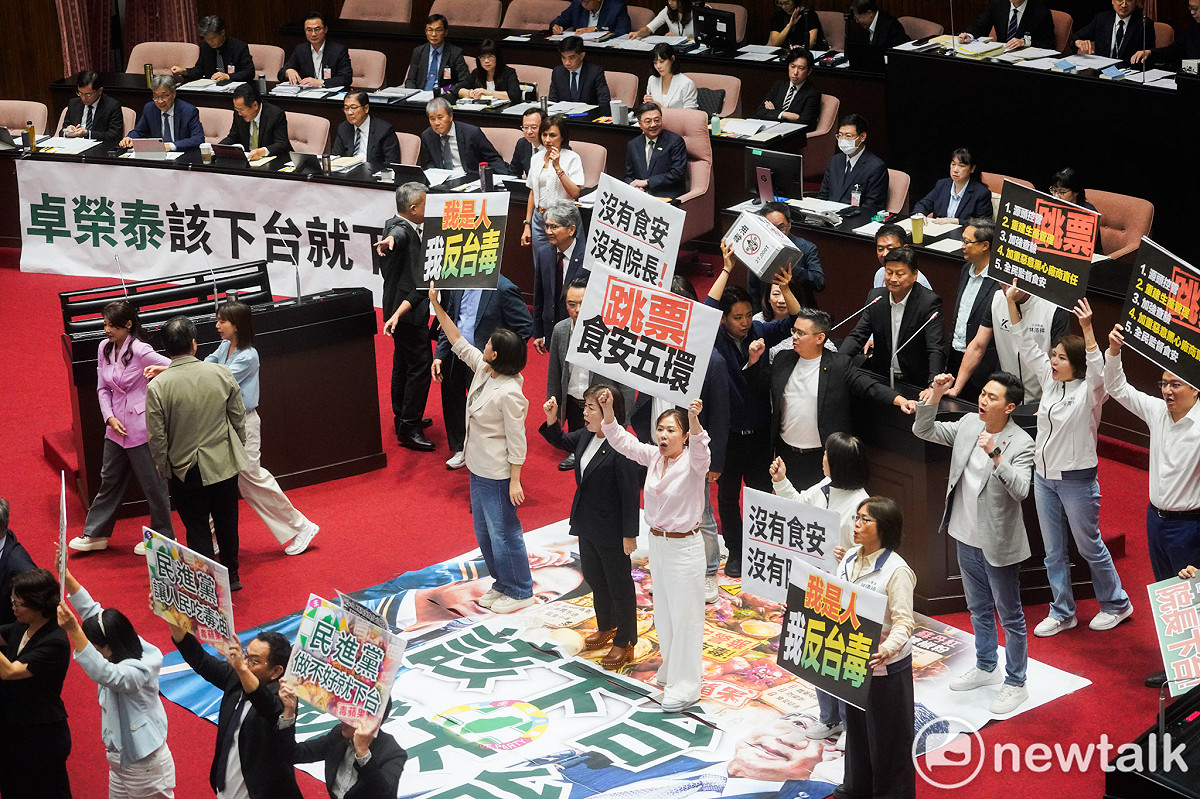 行政院長卓榮泰赴立法院就中聯油脂大豆沙拉油事件及食安監管機制缺失檢討專案報告並備詢，國民黨立委在議場內舉牌，阻擋卓榮泰進行專案報告。 圖：張良一/攝