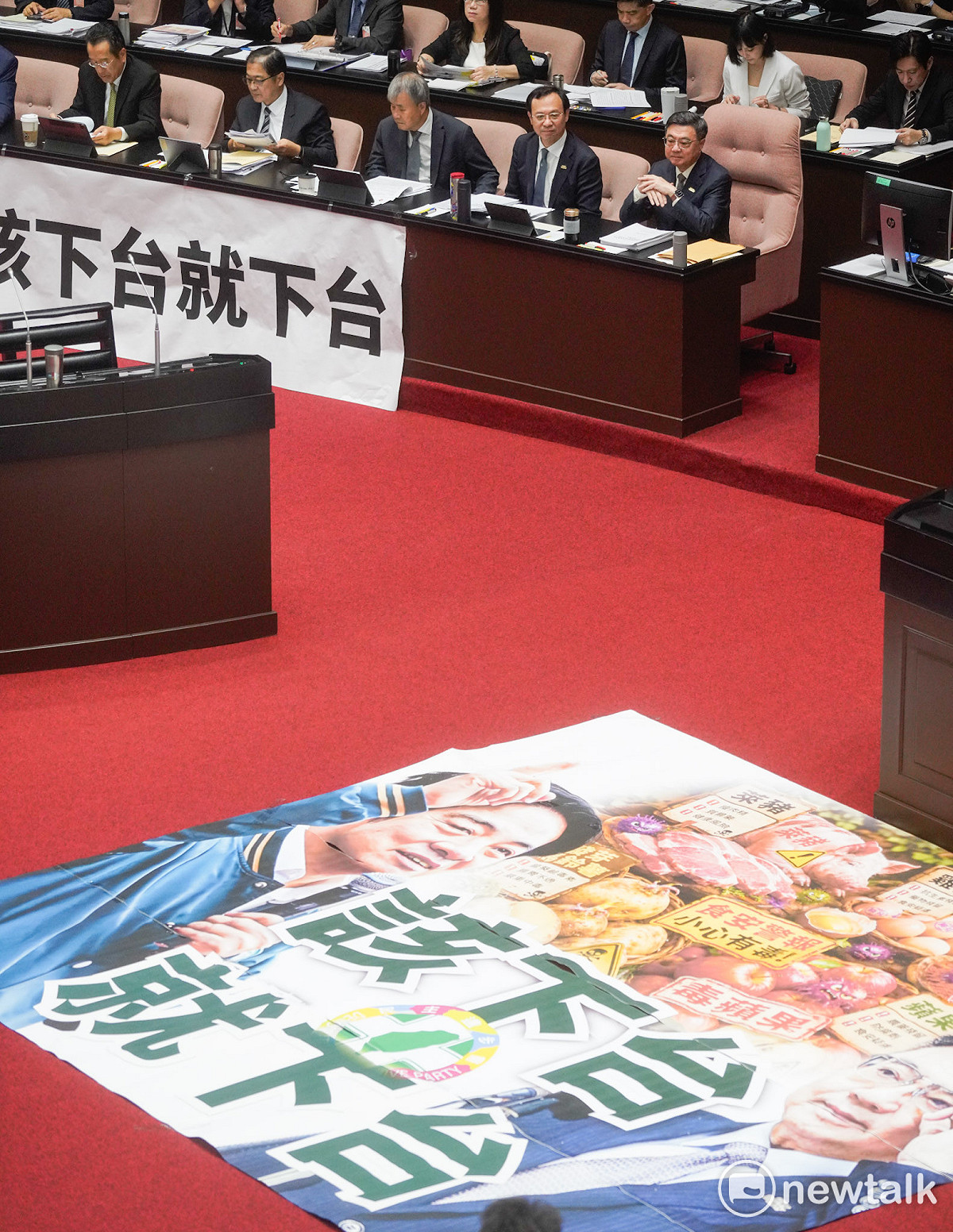 行政院長卓榮泰赴立法院就中聯油脂大豆沙拉油事件及食安監管機制缺失檢討專案報告並備詢，國民黨立委在官員席前面張開「該下台就下台」抗議標語。 圖：張良一/攝
