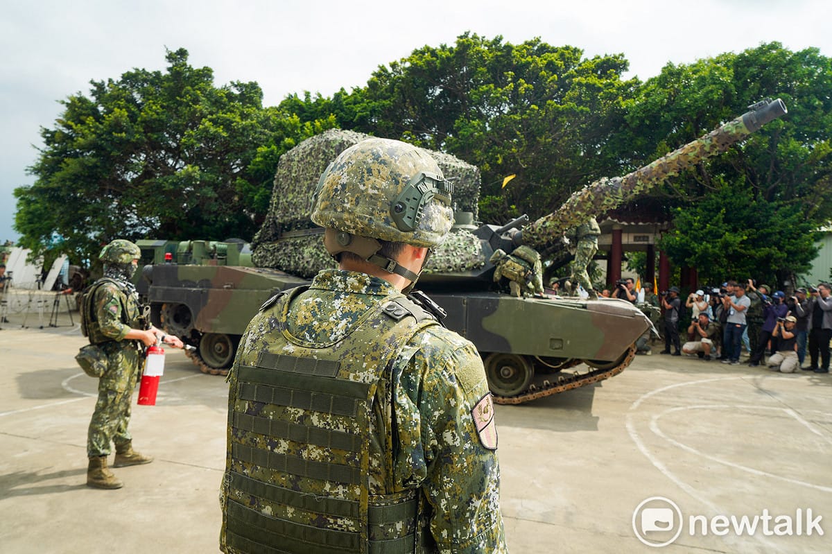陸軍584旅在漢光42號演習中，在桃園地區進行油料整補演練，加油時，一位士兵拿著滅火器在一旁警戒。 圖：張良一/攝