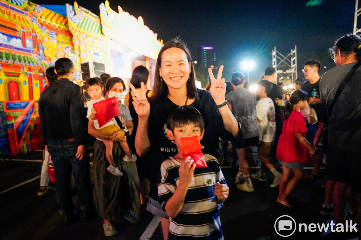 鍘美藝術節今晚首場由古都木偶戲團演出布袋戲《包公斬駙馬》，戲團演出前扮仙，工作人員依習俗將糖果與紅包往舞台下撒，吸引民眾爭搶。圖為一位媽媽和她的兒子展示她們搶到的紅包。 圖：張良一/攝