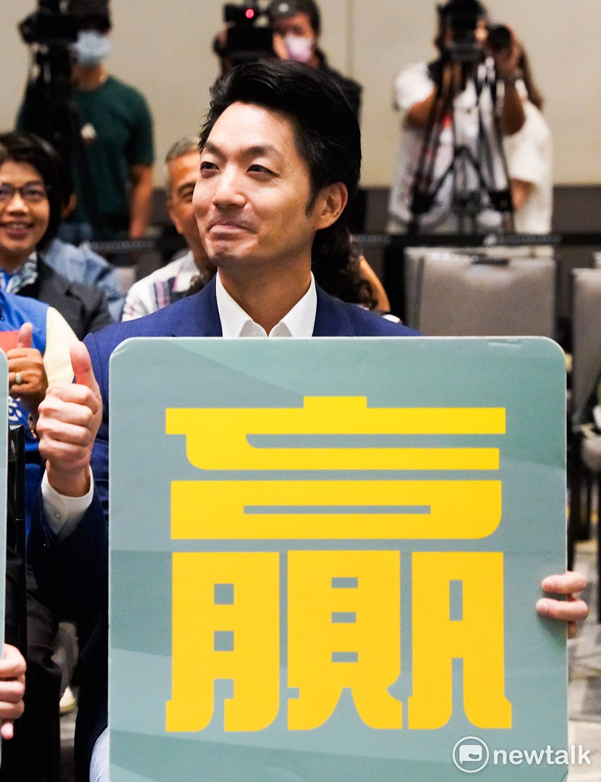 台北市長蔣萬安出席「 南機場整宅單元四公辦都更案」簽約典禮時，拿著「贏」字手舉牌和與會來賓合影。 圖：張良一/攝