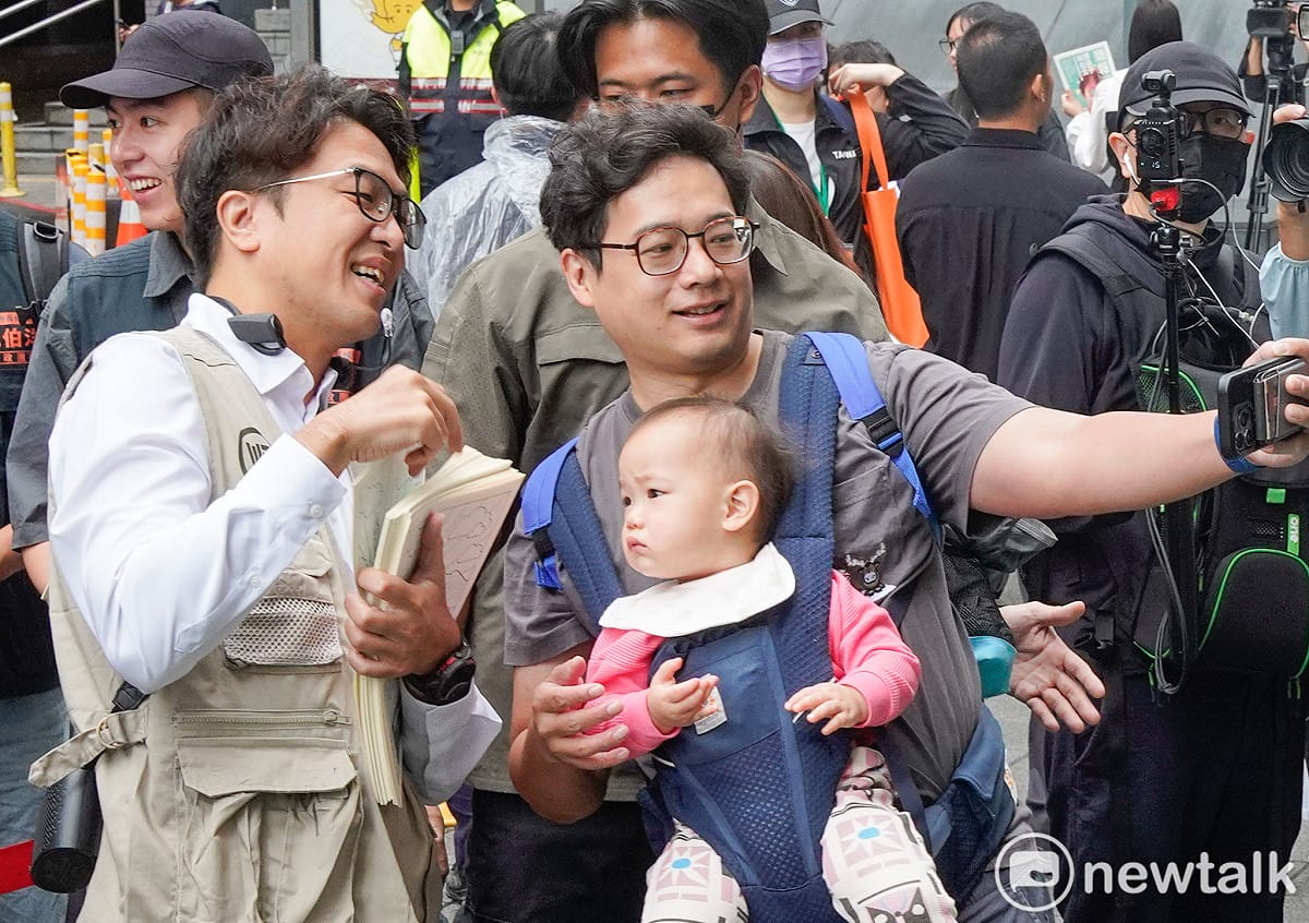 民進黨台北市長參選人沈伯洋到捷運南京復興站外發放第二期的順報時，一位小baby看著沈伯洋手上的順報。這一期的順報主題是育兒。 圖：張良一/攝