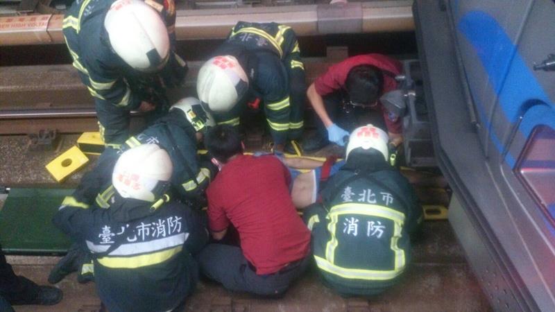 台北捷運公司指出，2日晚間一名年約十多歲歲男子在淡水信義線明德站（往象山方向）不慎落軌遭列車捲入，消防員獲報到場搶救，頭部撕裂傷急送榮總。 圖 : 中央社
