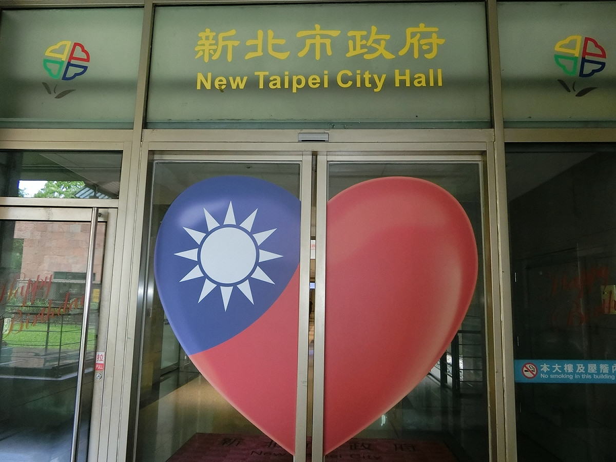 新北市今年以加強掛國旗來慶祝國慶，連市府側門上都印上大大的國旗愛心圖案。 李書璇/攝
