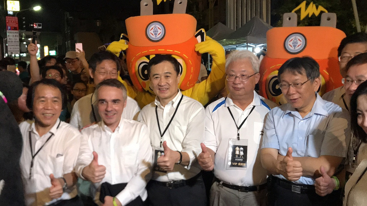 白晝之夜開幕，台北市長柯文哲踩街至台電大樓，與台電董事長朱文成共同以光棒點亮白晝之夜，台電以回收路燈打造的公共藝術日光域也打出白晝之夜「Nuit Blanche」法文活動名稱。 圖：台電公司提供