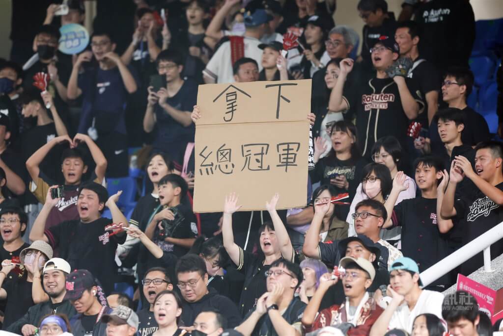 中職總冠軍賽（台灣大賽）26日在桃園棒球場進行第4戰，樂天桃猿隊以3比1擊退兄弟，奪下3勝聽牌優勢，場邊桃猿球迷拿紙板寫下「拿下總冠軍」為球隊加油。（中央社檔案照片）
