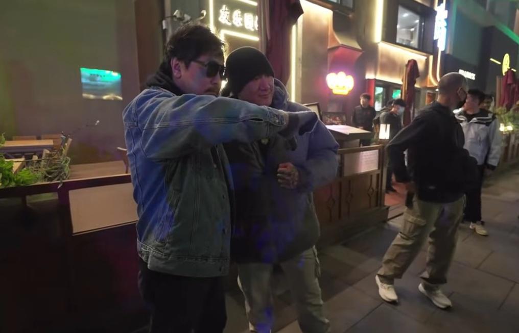 館長陳之漢北京行，遇到一名神秘男子上前合照，不僅比出倒讚，還在耳邊親嗆一邊一國，引發熱議。 圖：翻攝自館長惡名昭彰