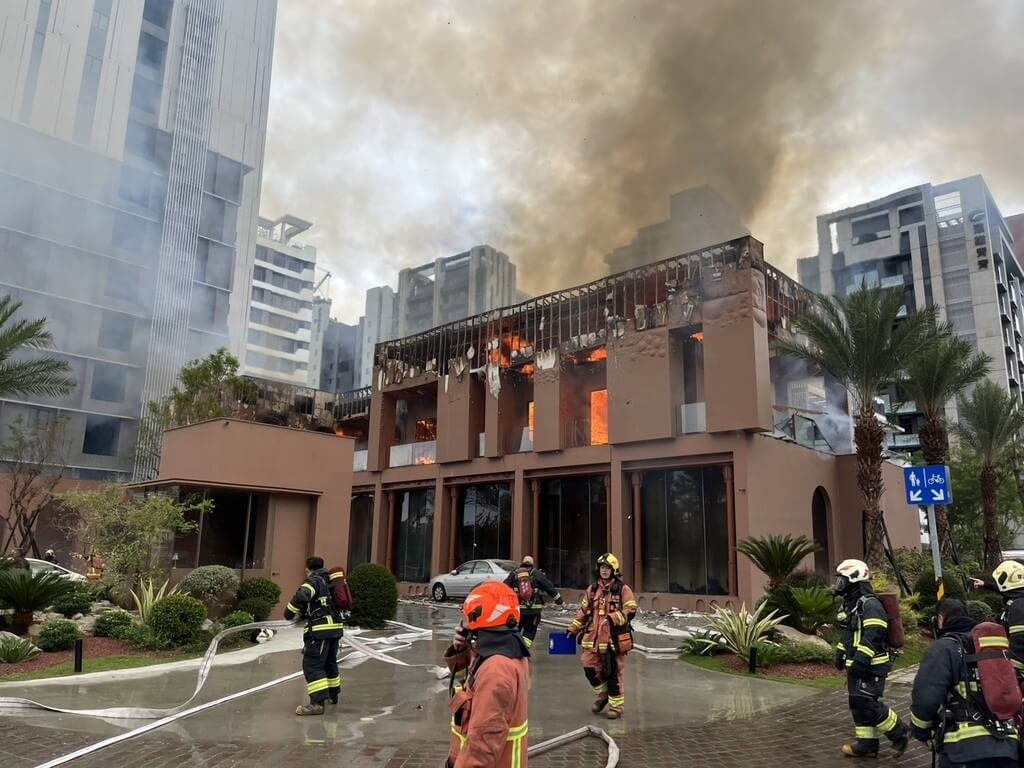 新北市新店區一間木造樣品屋30日起火燃燒，竄出濃煙，消防員布線灌救，幸無人受困。（新北市消防局提供）中央社記者曹亞沿傳真　114年10月30日