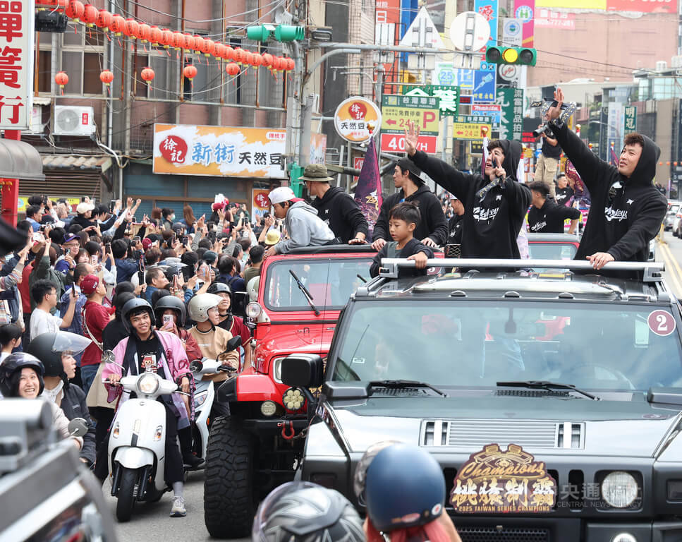 中華職棒樂天桃猿封王遊行2日下午登場，路線從樂天桃園棒球場出發，一路至桃園市政府廣場，球員林泓育（車上右起）、林立向球迷揮手致意，一同歡慶奪冠喜悅。中央社記者張新偉攝　114年11月2日