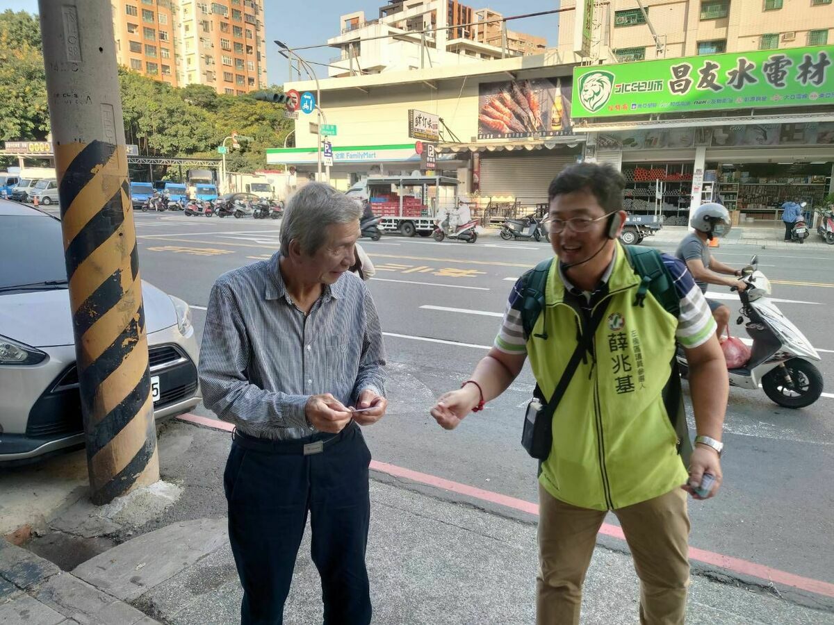 薛兆基(右)獨自沿著垃圾車路線，僅攜帶少量文宣與名片，與民眾近距離接觸。 圖：薛兆基競選總部/提供