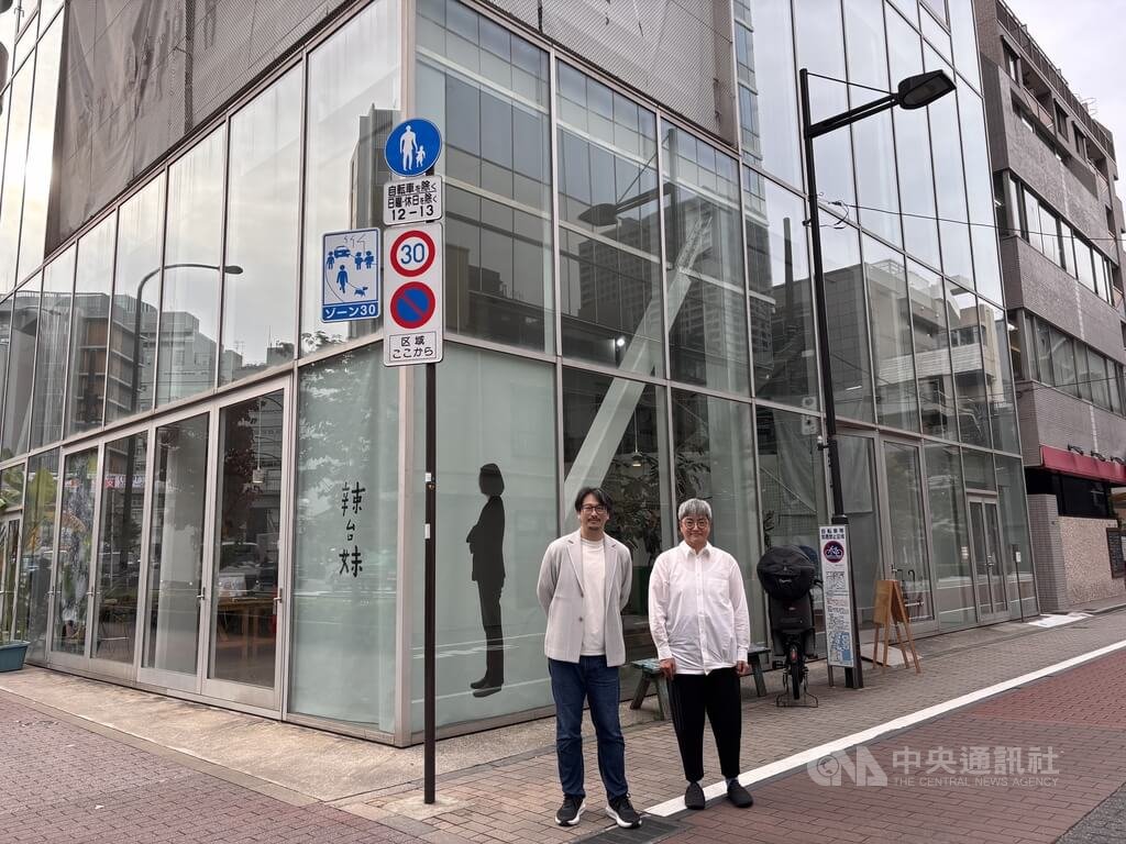 「辣台妹」藝術展日本巡迴展移師東京Shibaura House展出。場地由日本女性建築師妹島和世設計，建築物轉角處貼上蔡英文等身大的側身像，以及「辣台妹」書法文字，讓行人「轉角遇見蔡英文」。書法詩人何景窗（右）以及攝影藝術家林育良在「蔡英文」前合影。中央社記者戴雅真東京攝　114年11月6日 圖：中央社提供