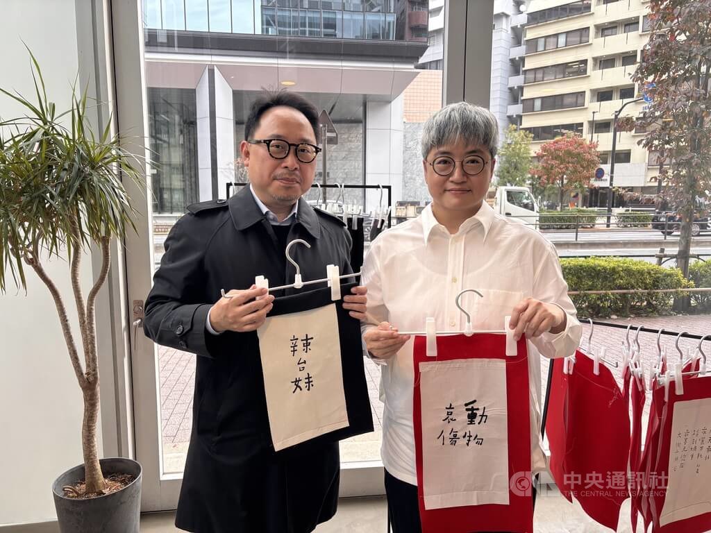 「辣台妹」藝術展日本巡迴展移師東京Shibaura House展出，書法詩人何景窗（右）以書法呈現詩句，把30件作品依照「辣台妹」、「動物哀傷」、「台日友好」3個主題，以線裝書的創意方式陳列，開幕儀式與文化部駐日台灣文化中心主任曾鈐龍合影。中央社記者戴雅真東京攝　114年11月6日 圖：中央社提供