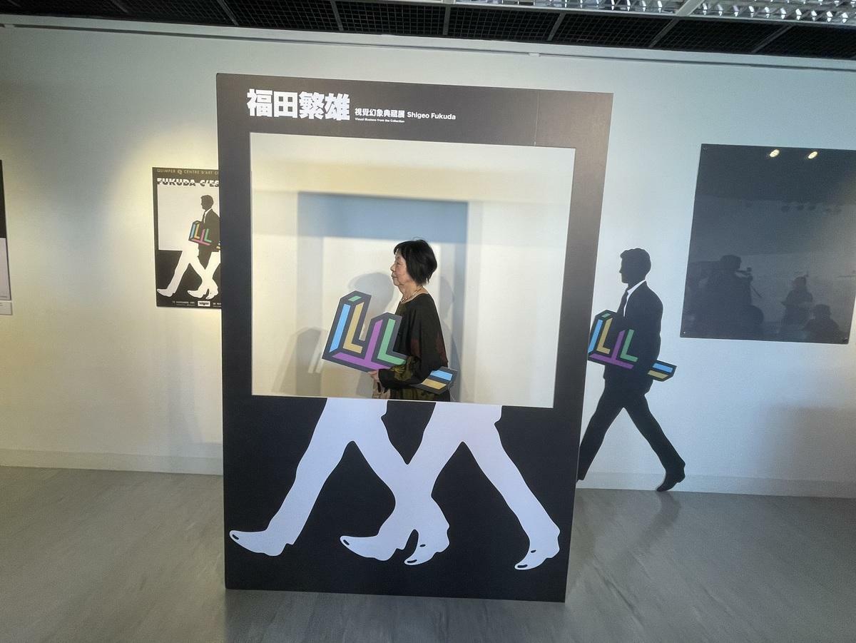 福田夫人與福田繁雄的作品一起自拍。 圖：高科大創新設計學院提供