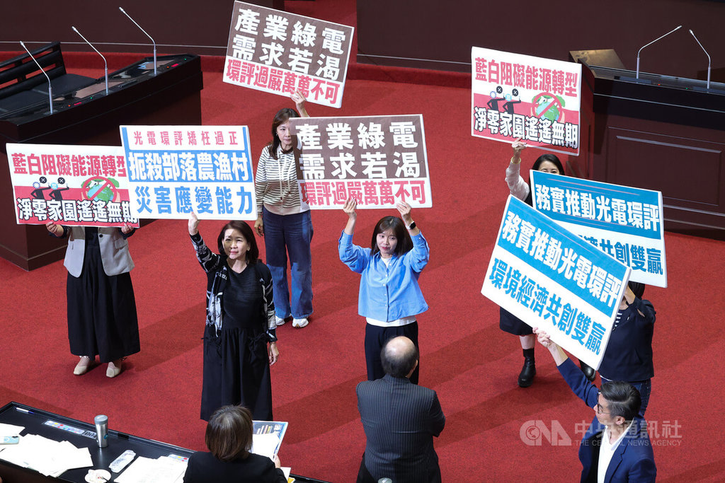 立法院14日下午針對環境影響評估法修正草案進行朝野協商，民進黨立委拿著各式手舉牌表達意見。 圖：中央社