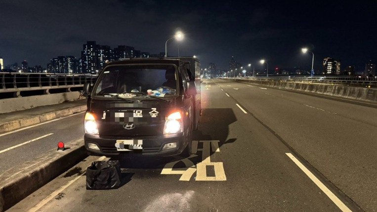保全公司運鈔車錢袋掉落在板橋區浮洲橋上。警方與保全人員耗費近1小時，將硬幣撿回。 圖：警方提供