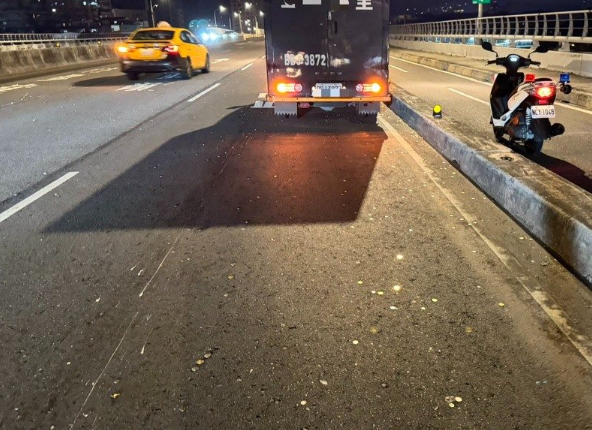 運鈔車疑似車門未關妥，袋裝硬幣直接灑落橋面。 圖：警方提供