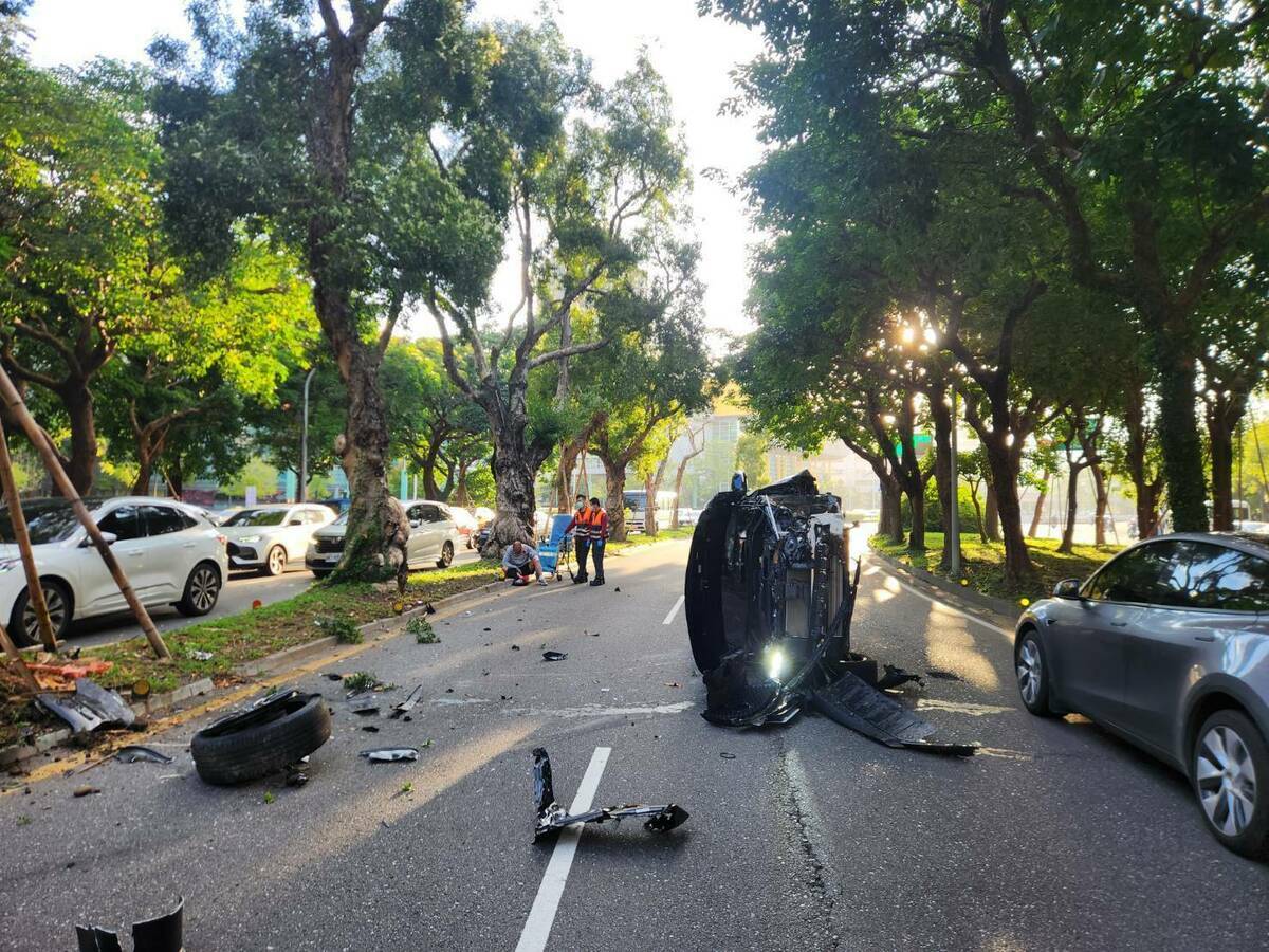 男子疑因恍惚未注意路況，自撞分隔島後，整輛車翻覆橫躺在路中央。 圖：翻攝自記者爆料網