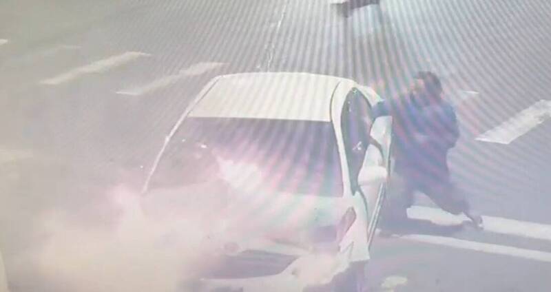 馬尾髮型男子見駕駛受困，隨即破窗救人，隨後車輛起火燃燒。 圖：翻攝畫面