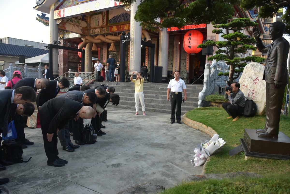 靖國神社代表團向已故前首相安倍晉三的銅像行禮致敬。 圖：孫家銘攝
