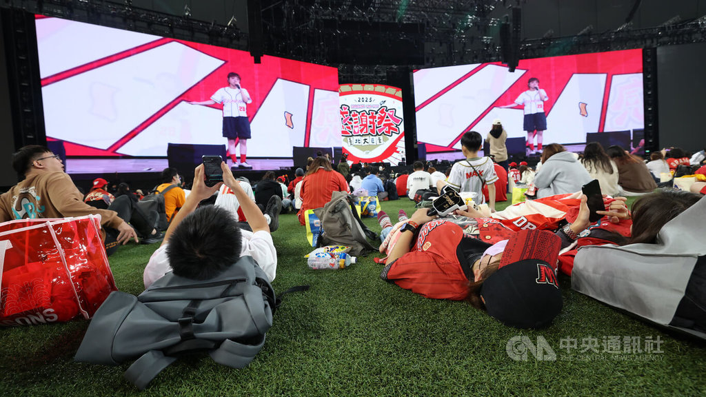 中職味全龍隊2025球迷感謝祭23日在台北大巨蛋舉行，吸引近萬球迷進場，晚間邀「小球」莊鵑瑛開唱，球迷躺草地欣賞。中央社記者張新偉攝　114年11月23日