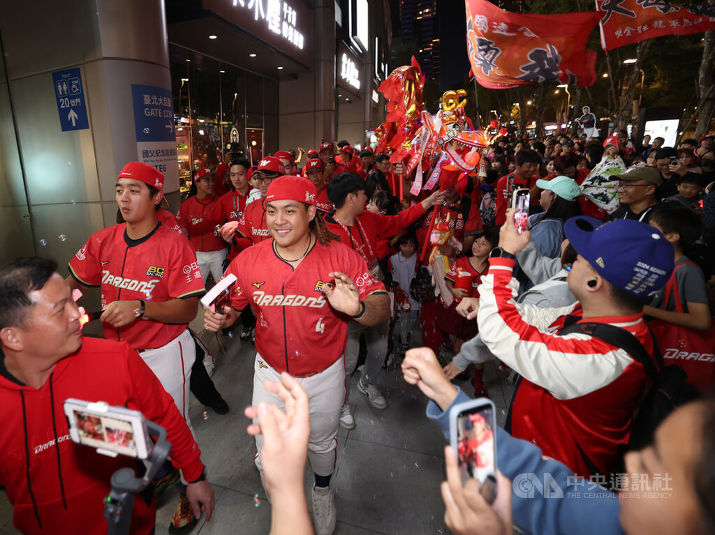 中華職棒味全龍感謝祭活動23日在台北大巨蛋落幕，球員吉力吉撈．鞏冠（2排左2）、拿莫．伊漾（2排左1）參與場外夜光遊行，向球迷揮手致意。中央社記者張新偉攝　114年11月23日