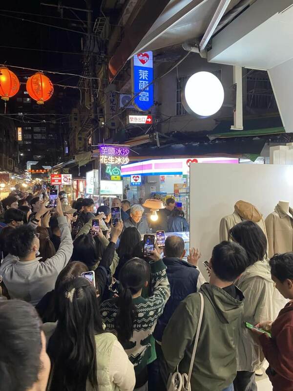 黃仁勳晚間前往台北市通化街夜市購買水果，吸引許多民眾圍觀拍照。（讀者楊旻哲提供）