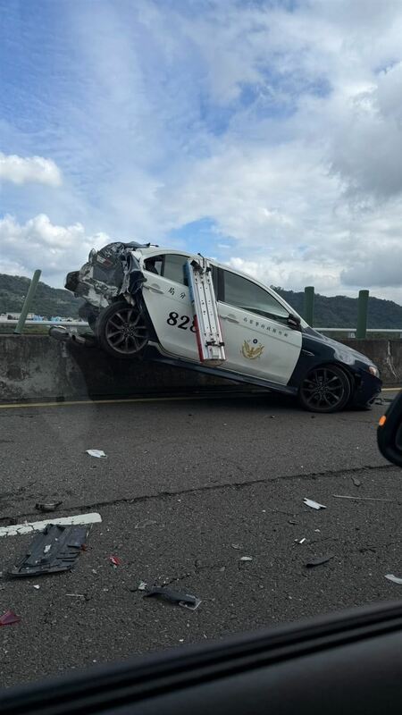 警車遭後方貨車追撞，車尾全毀更衝上中央分隔島。 圖：翻攝自臉書