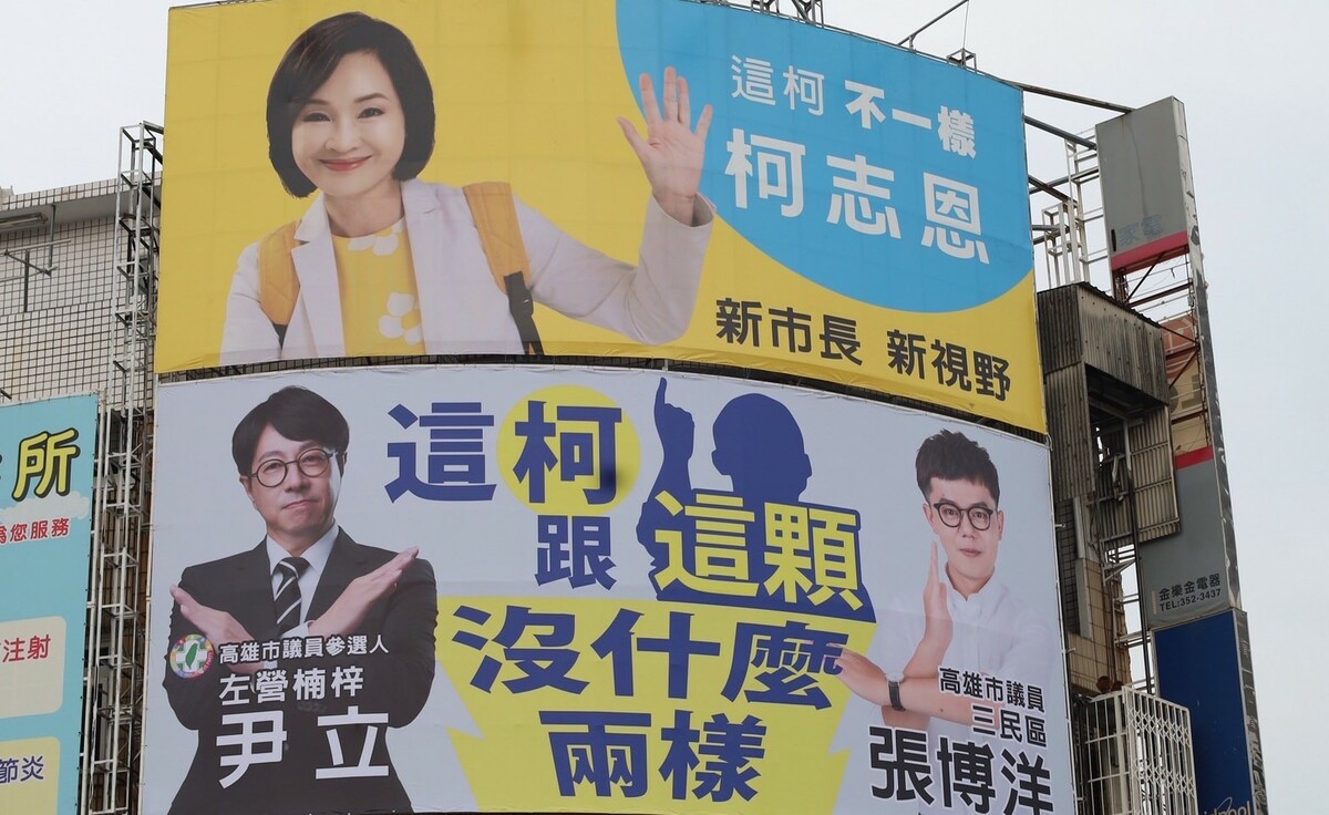 反諷柯志恩「這柯不一樣」，尹立與張博洋加掛「這柯跟這顆沒什麼兩樣」的看板。 圖：尹立競選團隊/提供