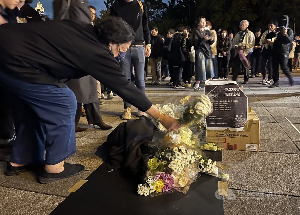 在台港人組成香港宏福苑火災台灣悼念關注組，6日晚在中正紀念堂自由廣場舉辦悼念晚會，民眾現場獻花。 圖:中央社提供