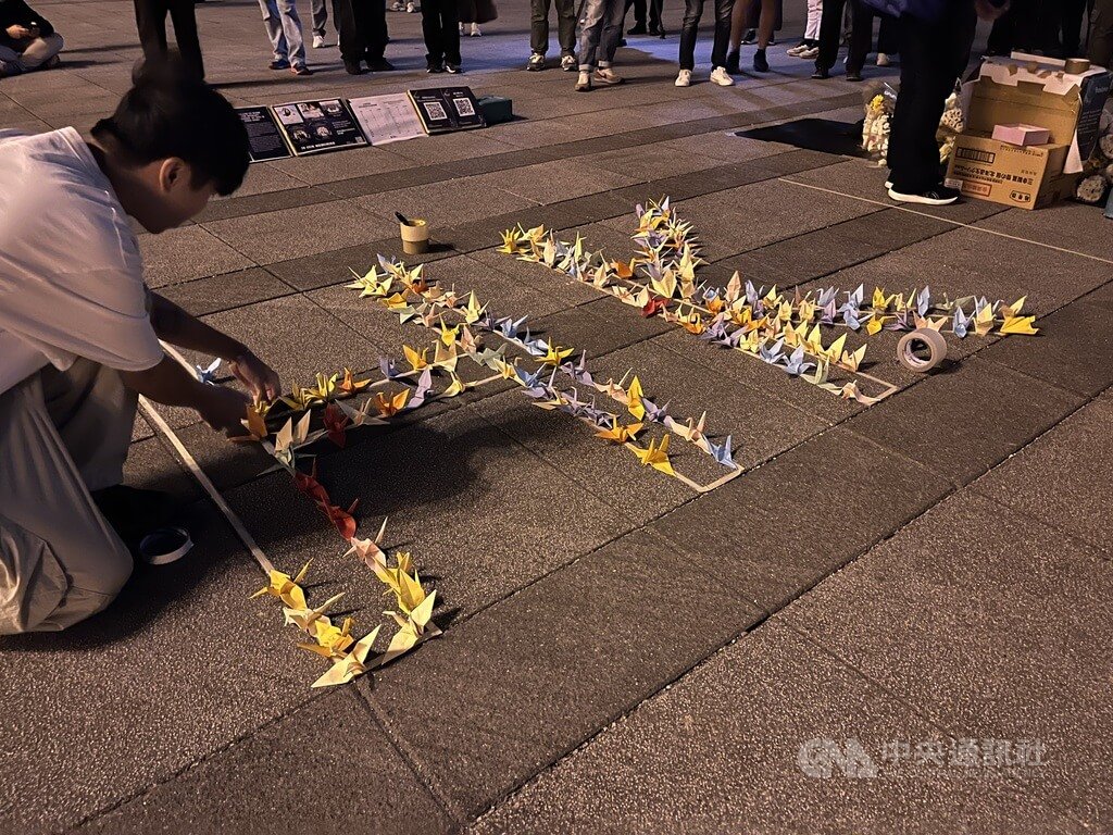 在台港人組成香港宏福苑火災台灣悼念關注組，6日晚在中正紀念堂自由廣場舉辦悼念晚會，現場用民眾手折紙鶴填滿「HK」字樣。 圖:中央社提供