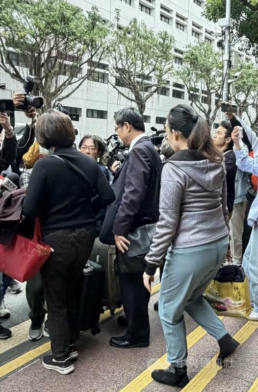 國民黨立委徐巧芯的大姑劉向婕（前右背對者）涉洗錢案，高等法院裁定新台幣80萬交保並電子腳鐶監控，交保手續完成後，劉向婕步出法院。中央社記者劉世怡攝　114年12月8日