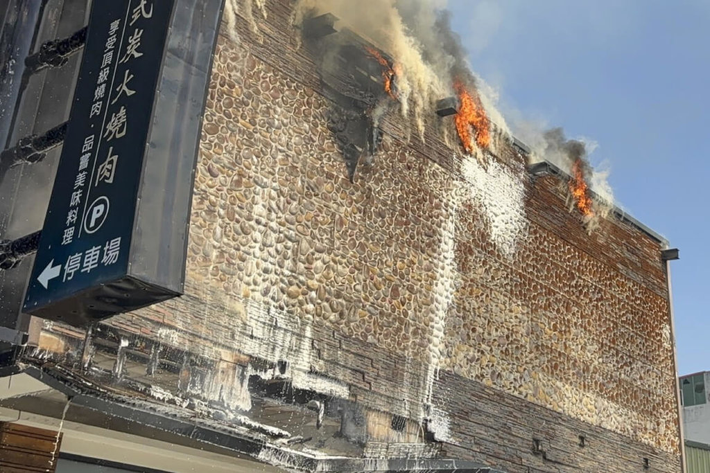 台南市中西區一間已歇業燒肉店外部廣告看板處9日中午起火燃燒，消防人員獲報前往撲滅，未造成延燒及人員傷亡。（讀者提供）中央社記者楊思瑞台南傳真　114年12月9日