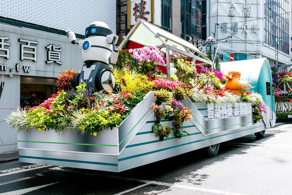 第三輛花車「智慧科技．農業創新」車頭呈現雲端科技的意象，搭配車身裝置採用無人機、智慧機器人跟環境控制型的強固型溫室，以最新科技農業的元素建置花車。 圖：農委會/提供