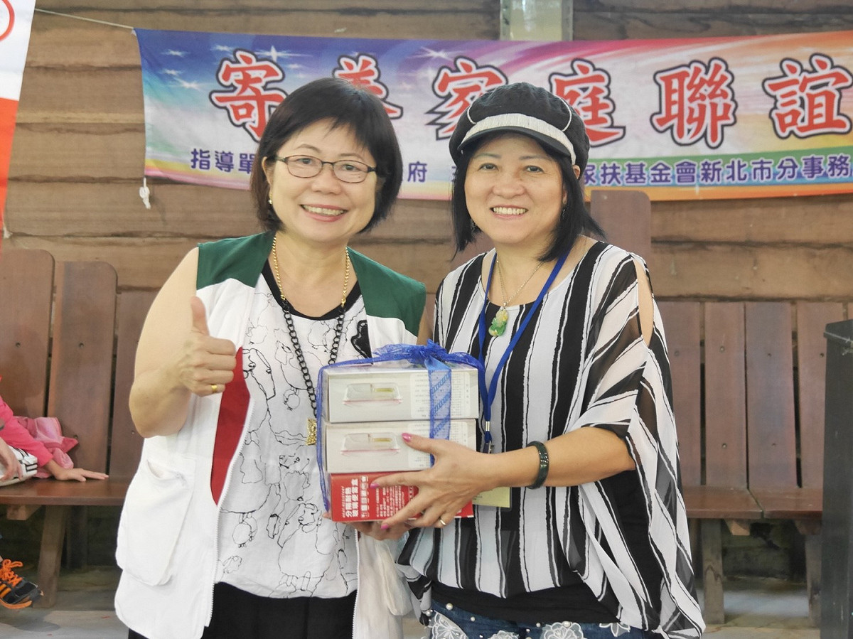 陳美君主任代表新北家扶贈送禮物給寄養家長代表春秀媽媽，感謝長期對寄養兒童的付出。 圖：家扶基金會/提供