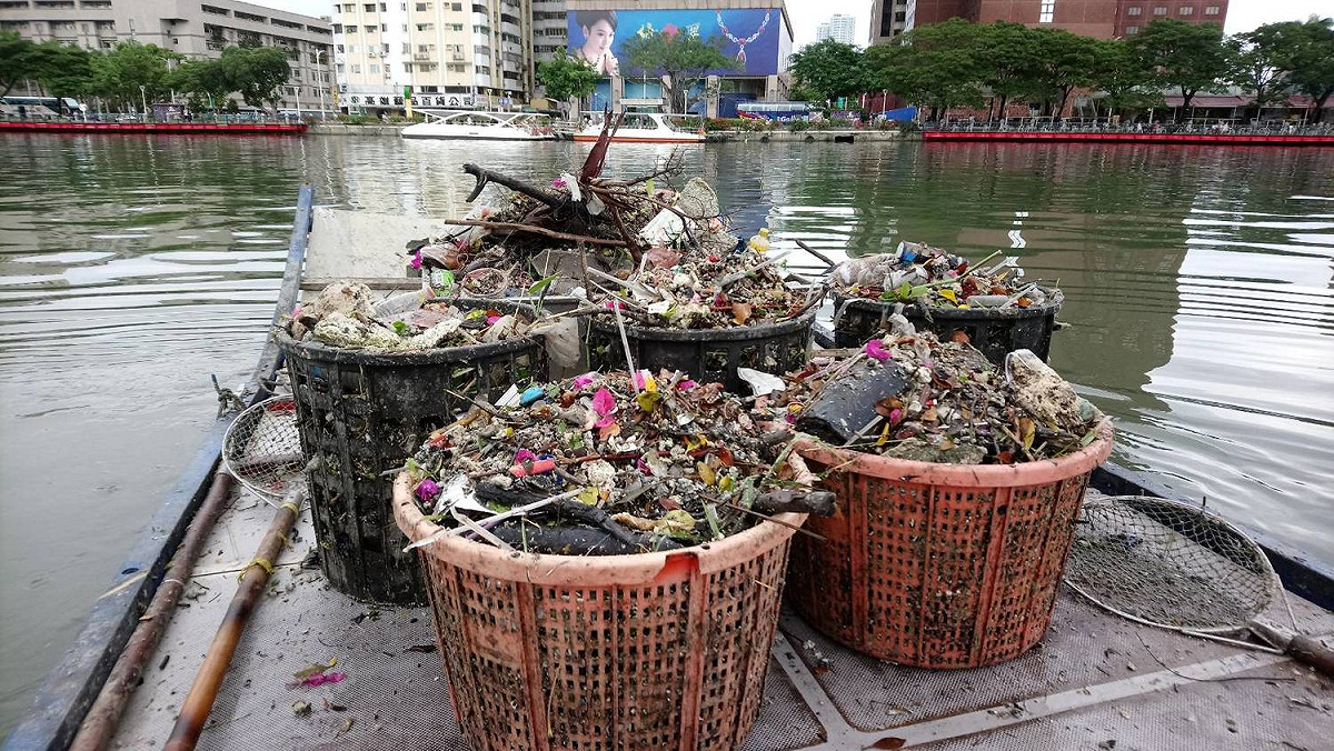 環保局溝渠隊的清潔隊員，自大雨停後就開始以2人一組，搭乘膠筏在河面上打撈漂浮垃圾；這二天已經打撈1,700公斤的垃圾，大約是平時的三倍量。 圖：高雄市環保局/提供