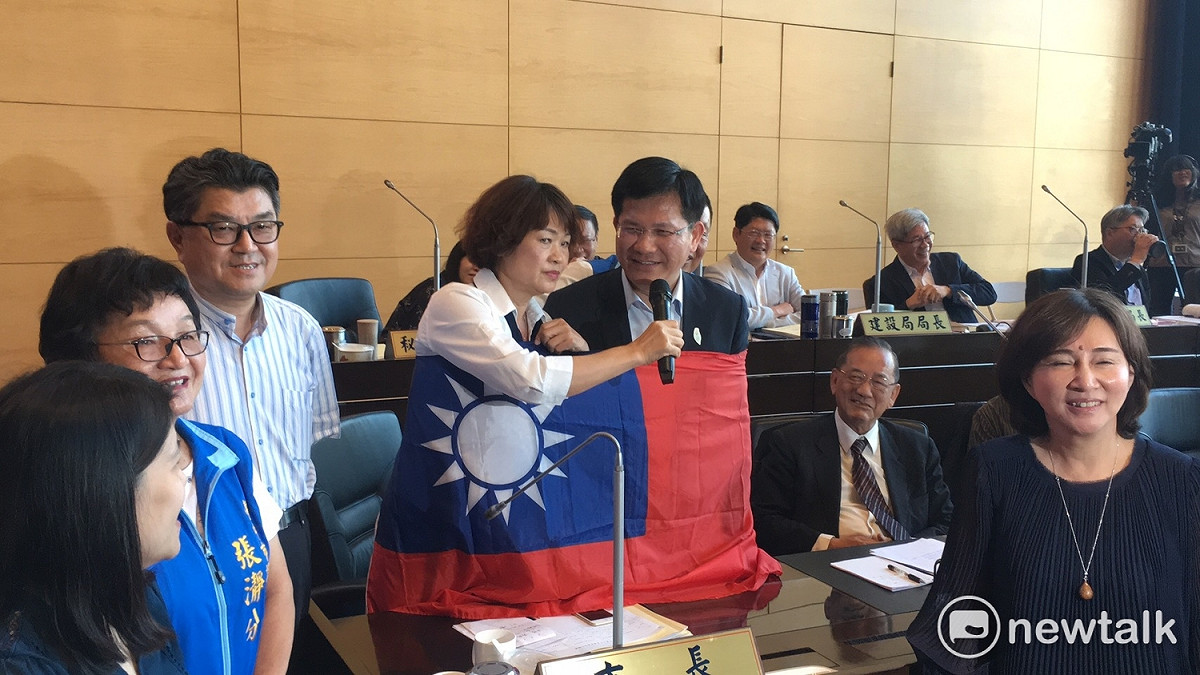 國民黨市議員李麗華拿國旗包住林佳龍，還問他是哪一國的市長。 圖 : 唐復年/攝