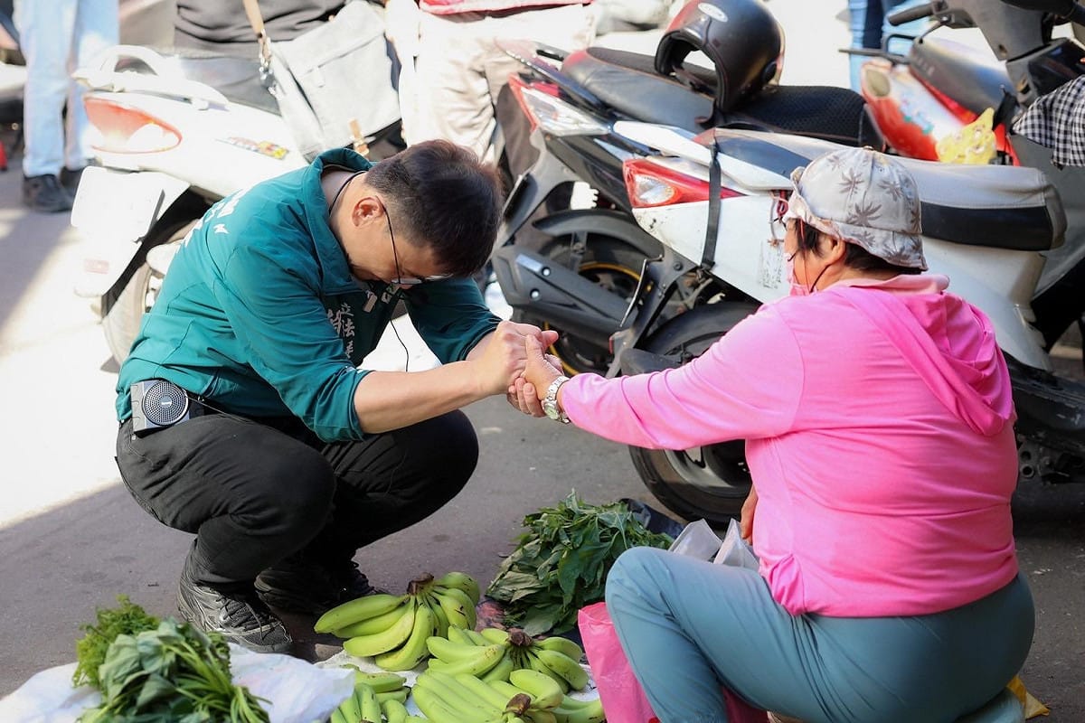 賴瑞隆(左)前往小港區二苓市場向攤商掃街拜票。 圖：賴瑞隆辦公室/提供