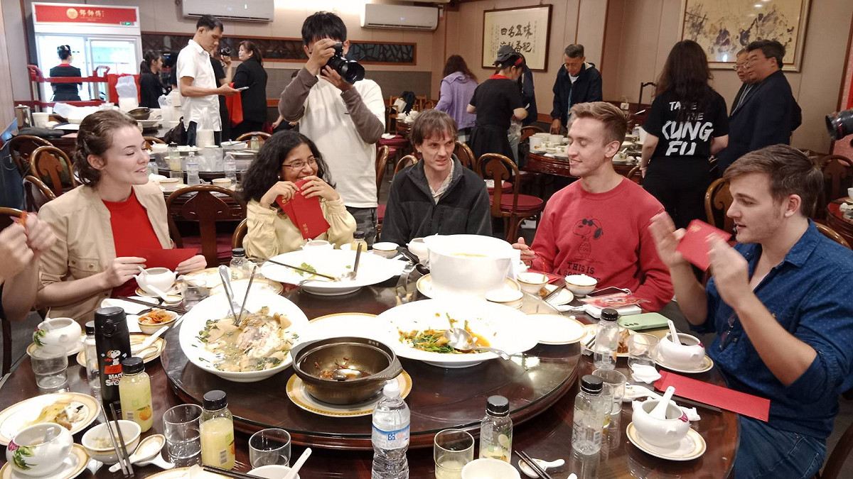 文藻外語大學國際學生飽嚐台式年菜，還收到鄧師傅功夫菜提供的紅包，提前體驗台灣過年氣氛。 圖：孫家銘攝