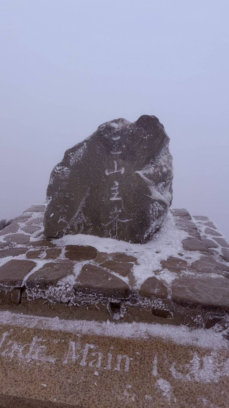 今日玉山北峰6時28分到38分降雪，雖然時間只有10分鐘，但之後持續下冰霰，讓山區變成一個大冰庫，更讓玉山北峰石碑染了白頭。 圖：玉管處／提供