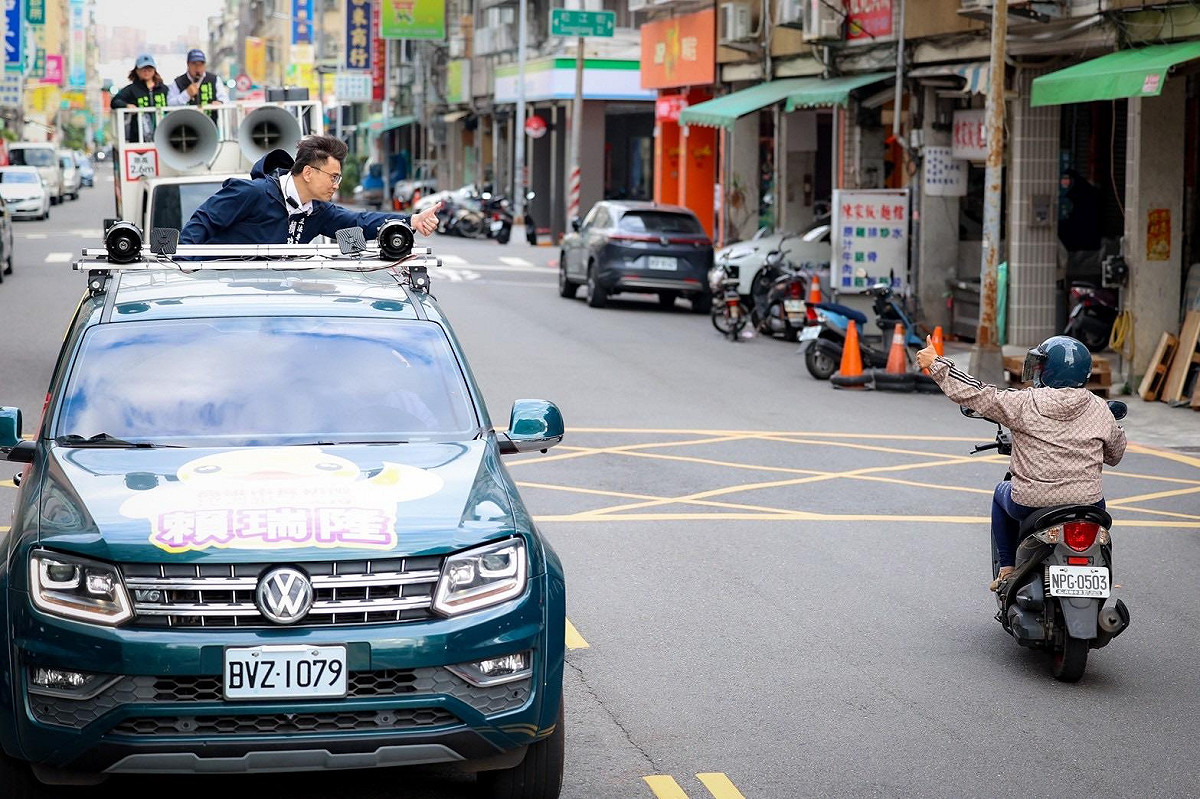 賴瑞隆(左)車掃與路過的騎士互相揮手致意。 圖：賴瑞隆辦公室/提供