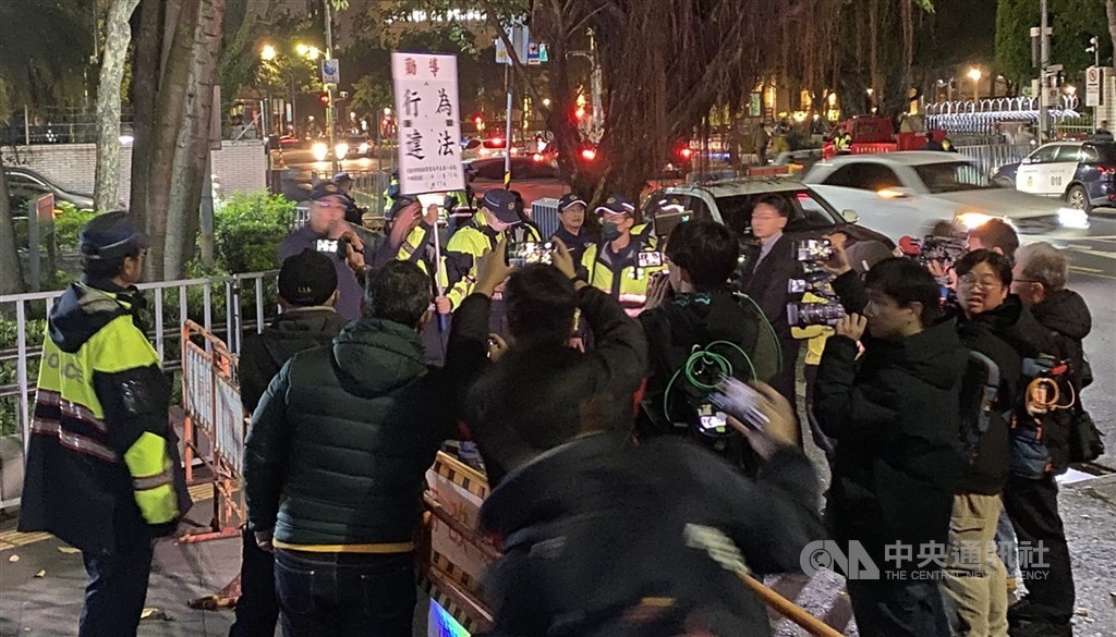 前台北市長柯文哲涉及京華城等案，台北地方法院於民國113年12月26日召開羈押庭。群眾至台北地檢署外抗議，警方舉牌警告。（中央社檔案照片）
