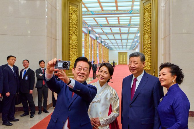 傳習近平在與李在明會晤期間，要求李在明與中國一起「在更加變亂交織的世界中『做出正確的戰略選擇』」。圖為李在明拿著習近平贈送的華為手機，準備拍攝合照。 圖：翻攝自 @cskun1989 X 帳號