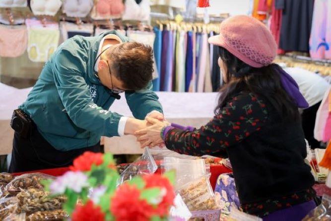 賴瑞隆(左)市場掃街，逐攤向攤商與採買民眾寒暄互動。 圖：賴瑞隆辦公室提供