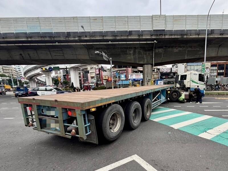 老婦一度受困拖板車底部。 圖：翻攝畫面