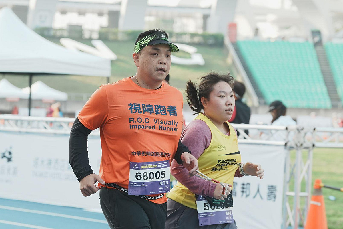 視障者(左)及陪跑員完成高雄富邦馬拉松休閒組賽事。 圖：高雄市運發局/提供