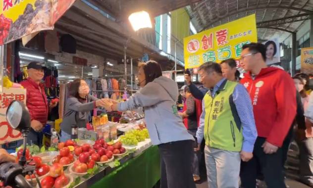 邱議瑩(中)與市場攤商握手爭取支持。 圖：孫家銘翻攝